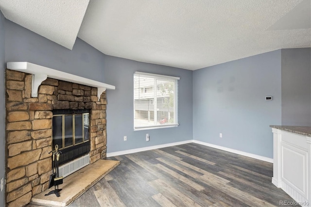 5250 S Huron Way Unit 1-204, Littleton, CO 80120 - unfurnished living room featuring a textured ceiling, dark wood-style floors, a fireplace, and baseboards