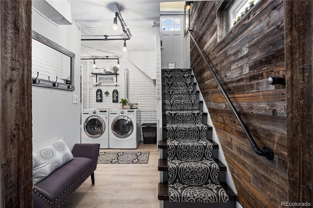 clothes washing area with washer and clothes dryer and light hardwood / wood-style flooring