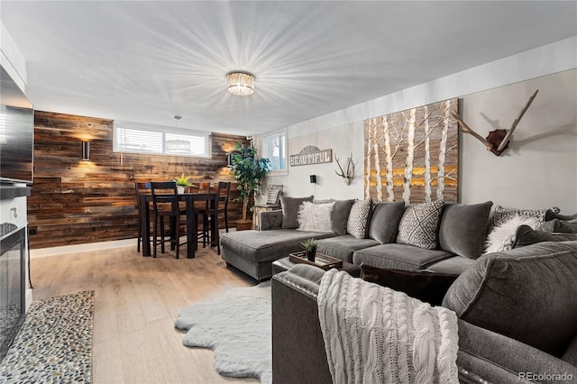 living room featuring wood walls and light hardwood / wood-style flooring