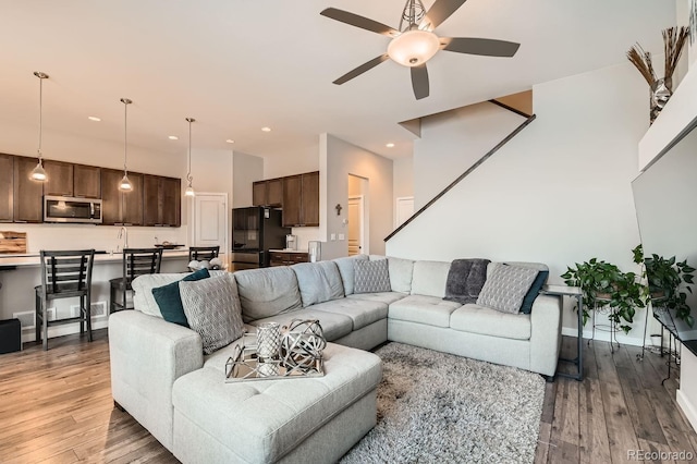 living room featuring light hardwood / wood-style floors, sink, and ceiling fan