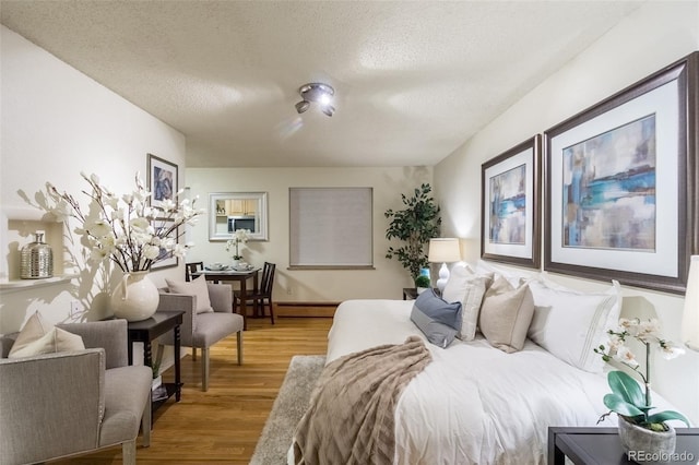 bedroom with a textured ceiling and wood finished floors