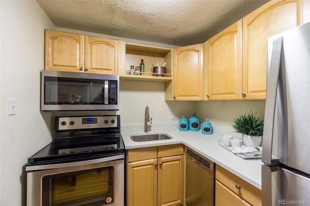 kitchen with light countertops, stainless steel appliances, light brown cabinets, and a sink