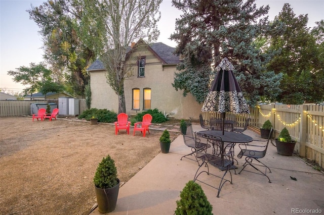 view of patio / terrace with an outbuilding, a shed, and a fenced backyard