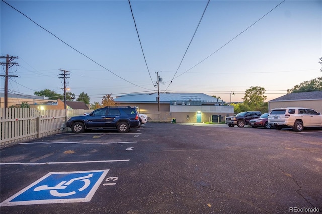 parking at dusk with uncovered parking and fence
