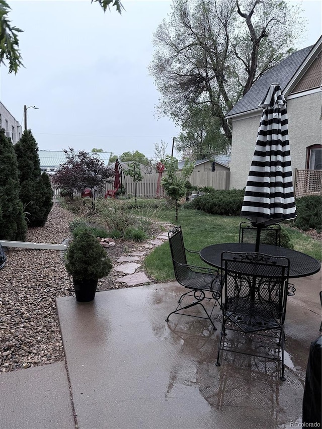view of patio featuring outdoor dining space and fence