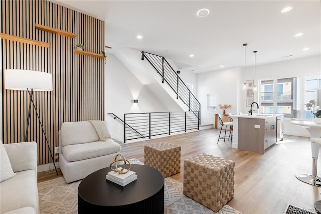 living room with light hardwood / wood-style floors and sink