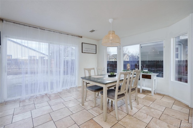 tiled dining space featuring a healthy amount of sunlight