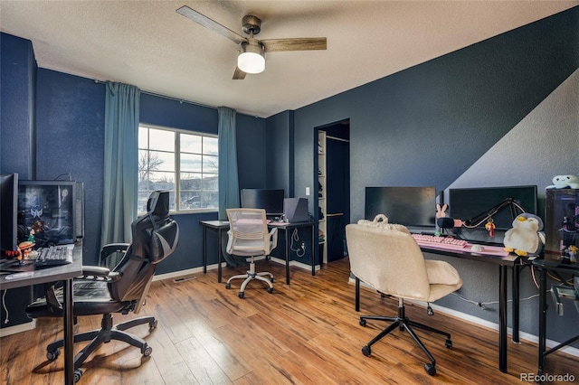 office space featuring hardwood / wood-style flooring, ceiling fan, and a textured ceiling