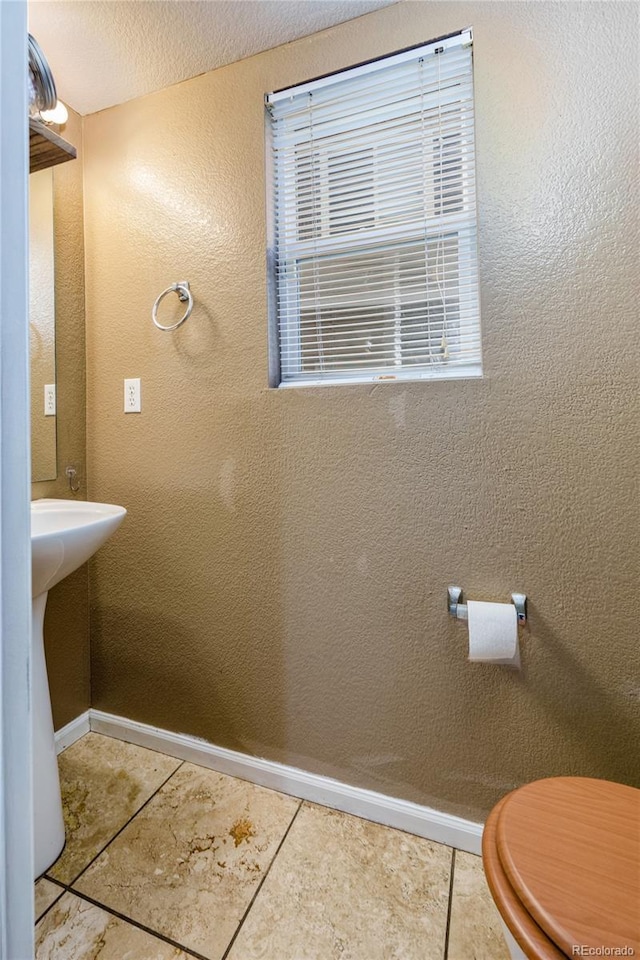 bathroom featuring tile patterned floors, a textured ceiling, and toilet