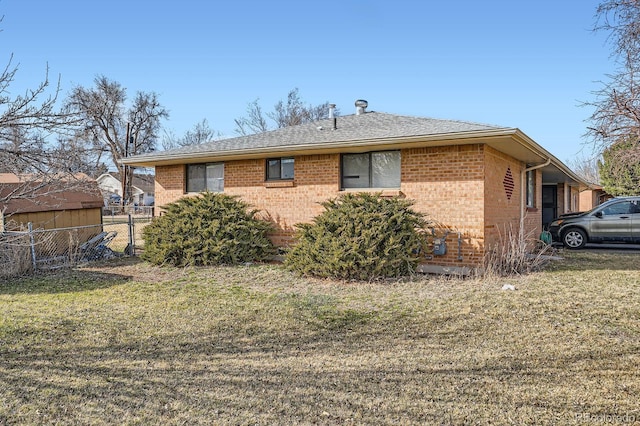 back of house with fence, brick siding, and a lawn