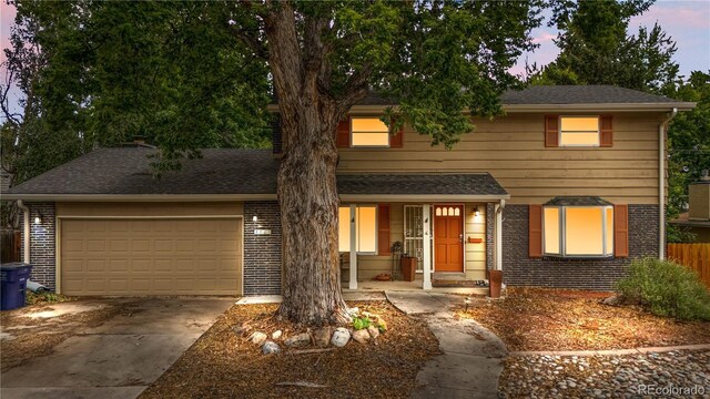 2730 S Jay St, Denver, CO 80227 - traditional home with covered porch, driveway, brick siding, and a garage