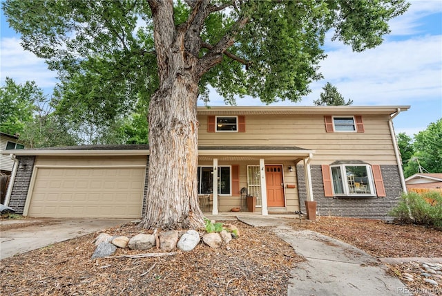 2730 S Jay St, Denver, CO 80227 - traditional home featuring a porch, driveway, a garage, and brick siding