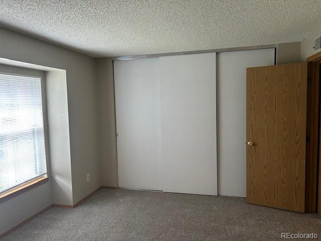 carpeted empty room featuring a textured ceiling