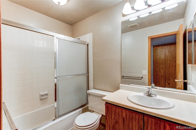 2690 E Otero Pl Unit 7, Centennial, CO 80122 - bathroom featuring a textured wall, toilet, vanity, and combined bath / shower with glass door