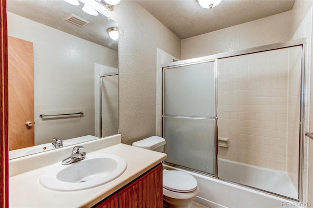 2690 E Otero Pl Unit 7, Centennial, CO 80122 - bathroom with a textured wall, toilet, bath / shower combo with glass door, and vanity