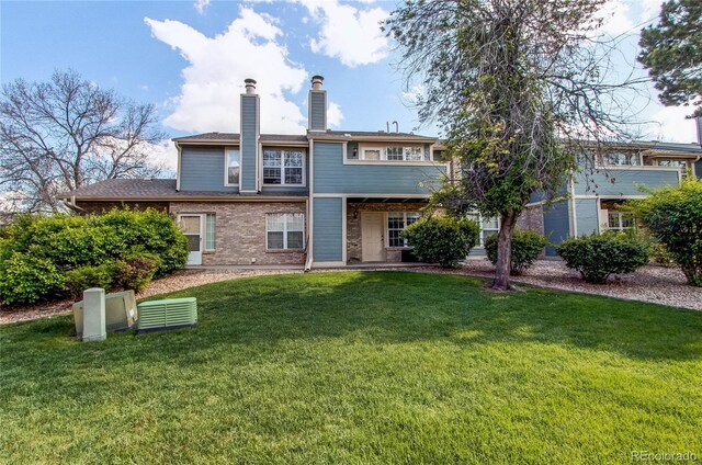 2690 E Otero Pl Unit 7, Centennial, CO 80122 - rear view of property with a lawn, a chimney, and brick siding