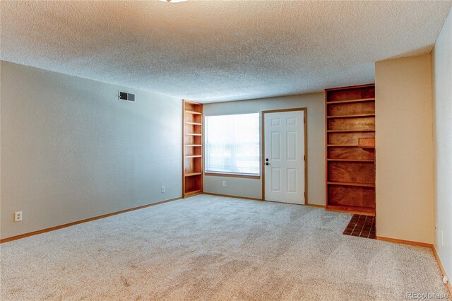 2690 E Otero Pl Unit 7, Centennial, CO 80122 - carpeted empty room with built in shelves, baseboards, and a textured ceiling