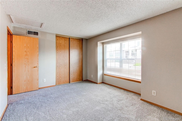 2690 E Otero Pl Unit 7, Centennial, CO 80122 - unfurnished bedroom featuring attic access, carpet, a textured ceiling, and baseboards