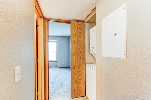 2690 E Otero Pl Unit 7, Centennial, CO 80122 - hall featuring stacked washing machine and dryer, electric panel, a textured wall, and light colored carpet