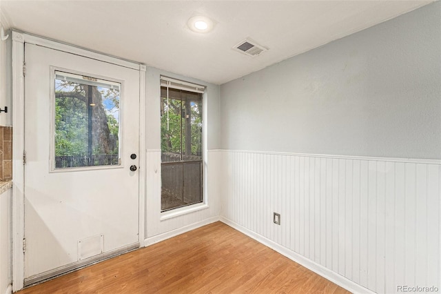 3550 S Harlan St Unit 105, Denver, CO 80235 - doorway featuring wood finished floors, plenty of natural light, and wainscoting
