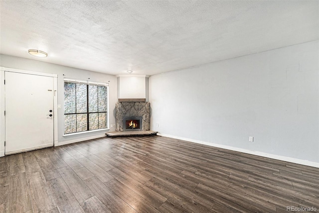 3550 S Harlan St Unit 105, Denver, CO 80235 - unfurnished living room featuring wood finished floors, a textured ceiling, and a fireplace
