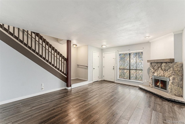 3550 S Harlan St Unit 105, Denver, CO 80235 - unfurnished living room with wood finished floors, a textured ceiling, stairs, and a stone fireplace