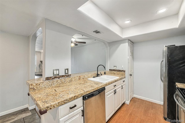 3550 S Harlan St Unit 105, Denver, CO 80235 - kitchen with stainless steel appliances, a peninsula, ceiling fan, arched walkways, and white cabinetry