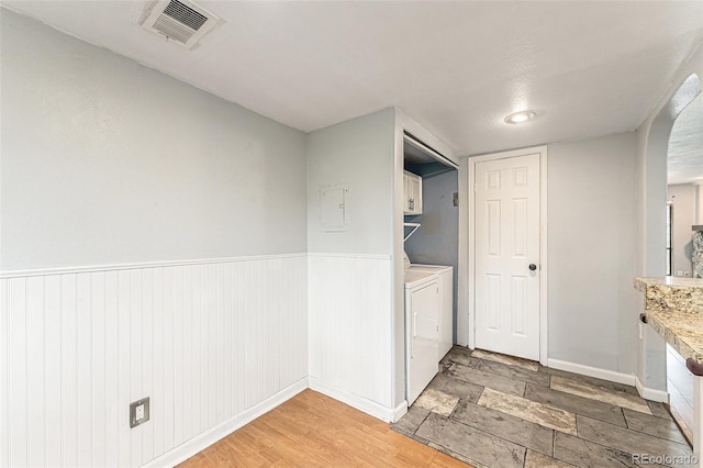 3550 S Harlan St Unit 105, Denver, CO 80235 - washroom with cabinet space, wainscoting, independent washer and dryer, and electric panel