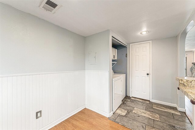 3550 S Harlan St Unit 105, Denver, CO 80235 - laundry room with cabinet space, a wainscoted wall, independent washer and dryer, and electric panel