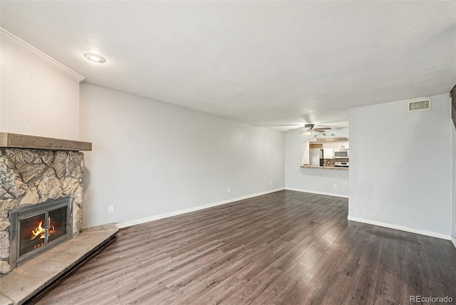 3550 S Harlan St Unit 105, Denver, CO 80235 - unfurnished living room with a stone fireplace, a ceiling fan, and dark wood finished floors