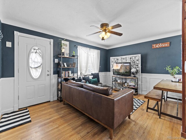1221 Ulster St, Denver, CO 80220 - living area featuring a ceiling fan, wainscoting, wood-type flooring, and a decorative wall