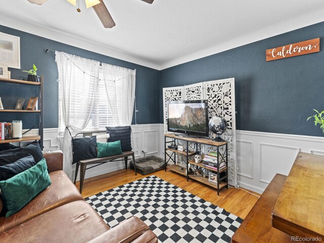 1221 Ulster St, Denver, CO 80220 - living area with wood finished floors, wainscoting, ceiling fan, and a decorative wall