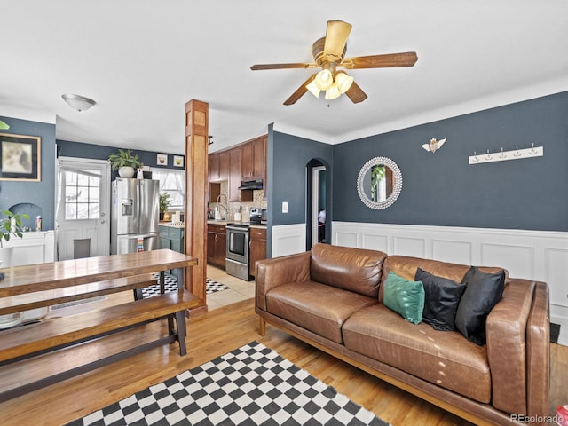 1221 Ulster St, Denver, CO 80220 - living area featuring a wainscoted wall, ceiling fan, and light wood-style flooring