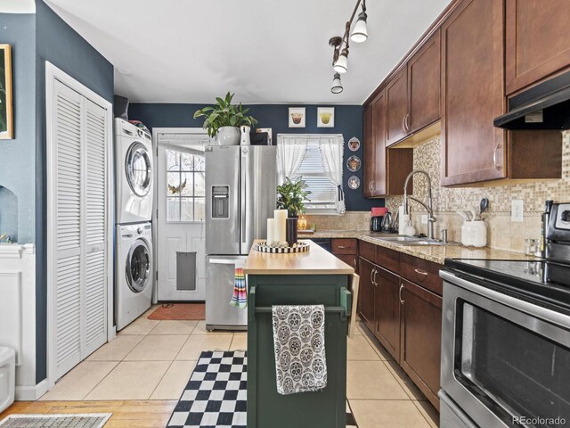1221 Ulster St, Denver, CO 80220 - kitchen featuring stainless steel appliances, stacked washing machine and dryer, a sink, and healthy amount of natural light