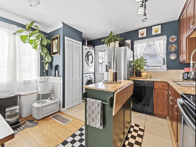 1221 Ulster St, Denver, CO 80220 - kitchen featuring stainless steel appliances, stacked washing machine and dryer, and a center island
