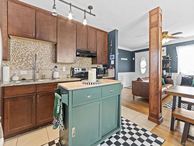 1221 Ulster St, Denver, CO 80220 - kitchen with under cabinet range hood, a sink, stainless steel electric range, plenty of natural light, and a wainscoted wall