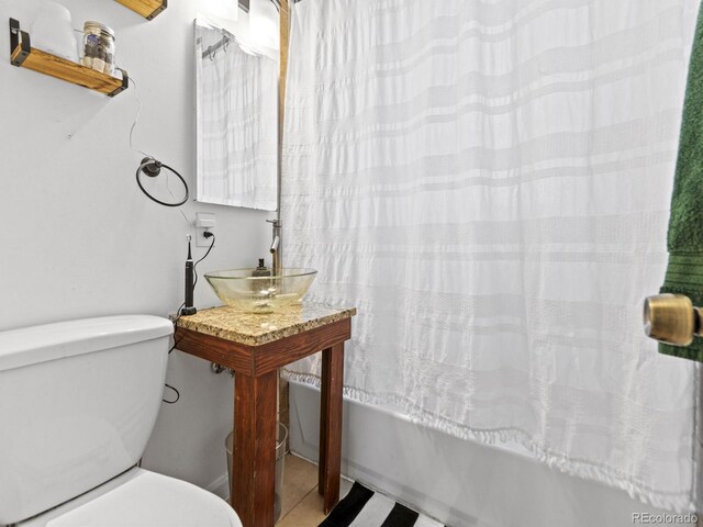 1221 Ulster St, Denver, CO 80220 - bathroom featuring toilet, shower / tub combo, a sink, and tile patterned flooring