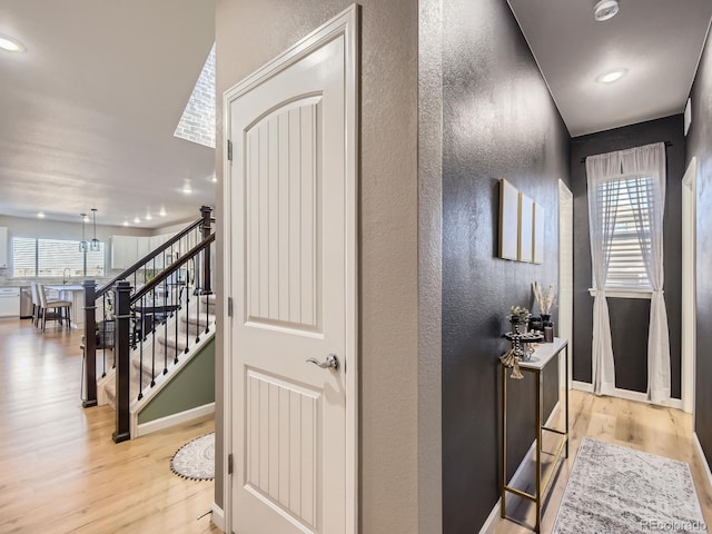 hallway with sink and light wood-type flooring