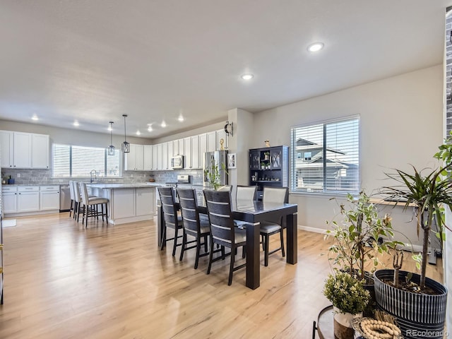 dining area featuring light wood-type flooring and sink