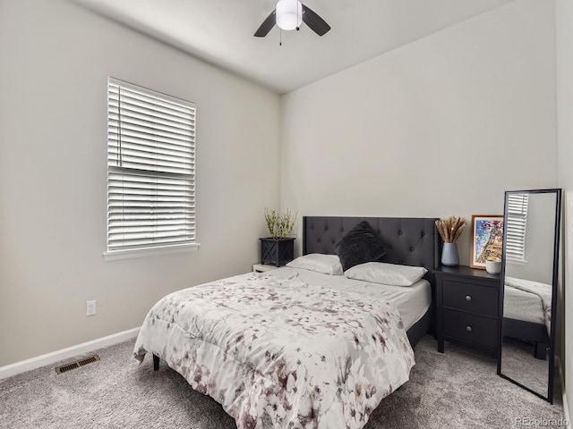 carpeted bedroom featuring multiple windows and ceiling fan