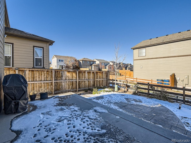 snow covered patio with a grill