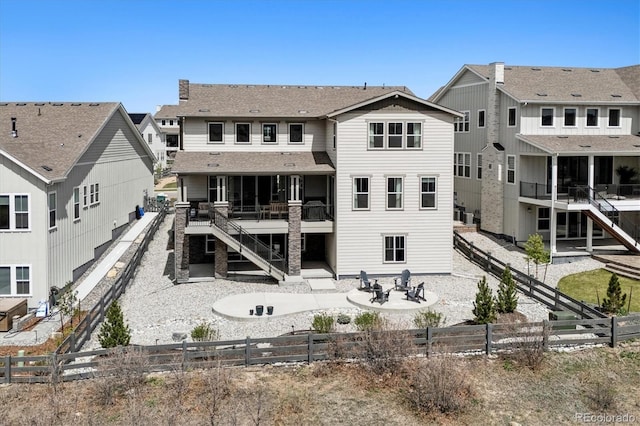 rear view of property with a patio, a residential view, stairway, a fire pit, and a fenced backyard