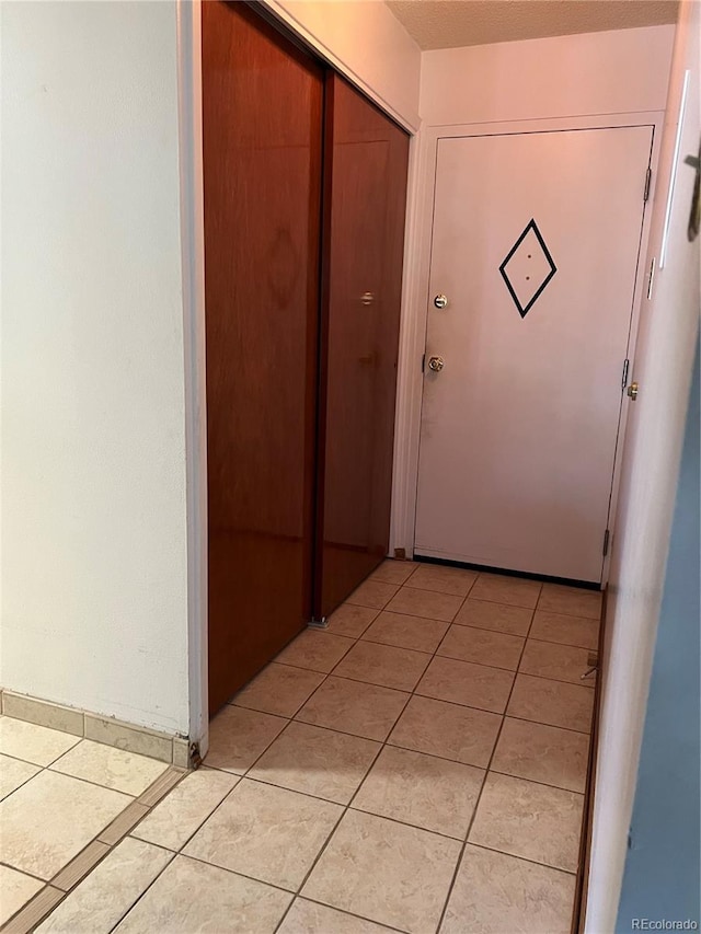 doorway to outside with light tile patterned floors