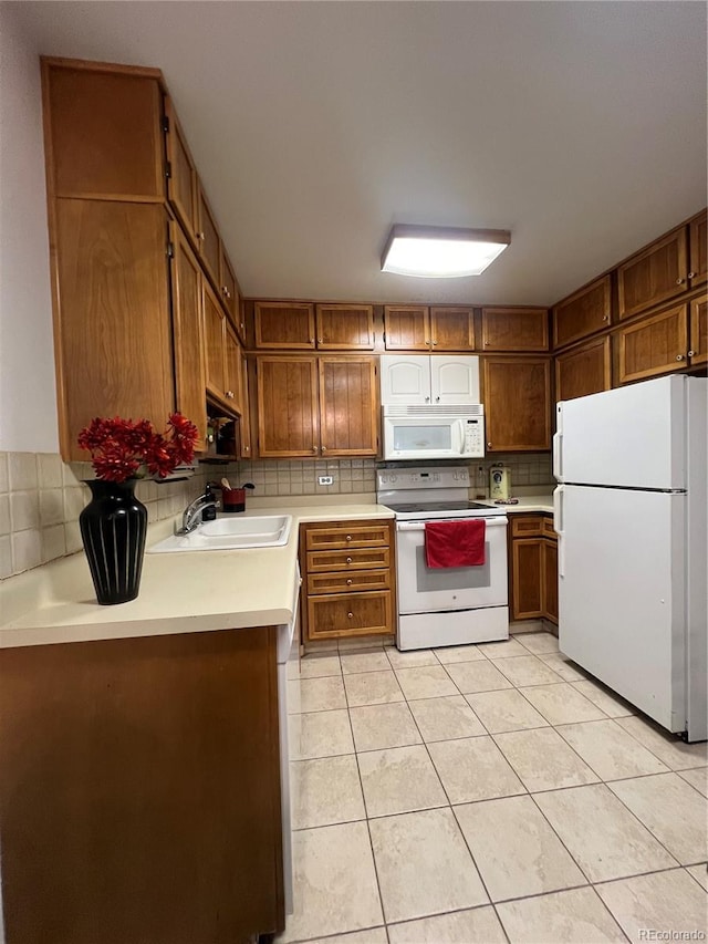 kitchen with light tile patterned floors, sink, white appliances, and tasteful backsplash