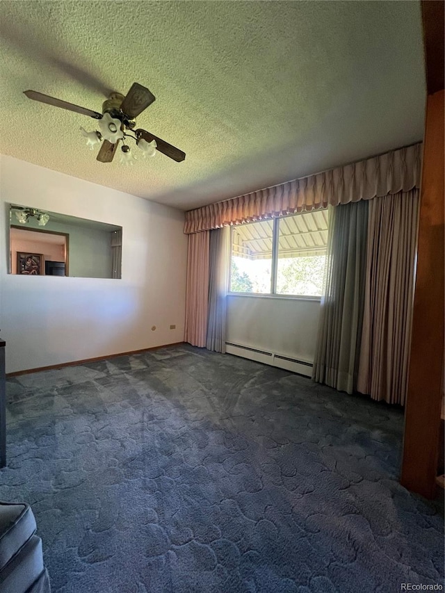 spare room with dark carpet, ceiling fan, baseboard heating, and a textured ceiling