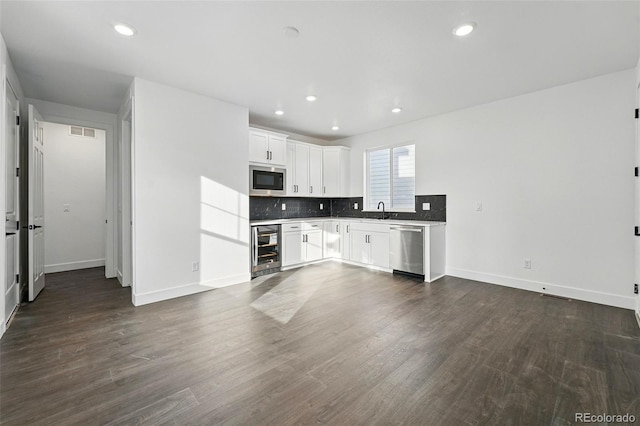 16549 Black Rose Cir, Parker, CO 80134 - kitchen with stainless steel appliances, wine cooler, dark wood finished floors, backsplash, and a sink