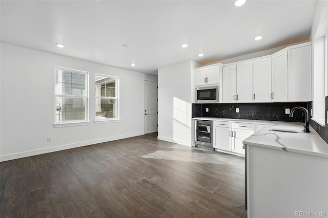 16549 Black Rose Cir, Parker, CO 80134 - kitchen with dark wood-style flooring, decorative backsplash, a sink, built in microwave, and beverage cooler