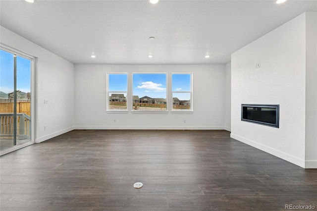 16549 Black Rose Cir, Parker, CO 80134 - unfurnished living room with a wealth of natural light, baseboards, and dark wood-type flooring