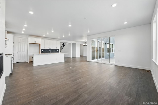 16549 Black Rose Cir, Parker, CO 80134 - unfurnished living room featuring baseboards, dark wood-style flooring, and recessed lighting