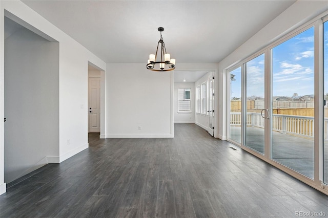16549 Black Rose Cir, Parker, CO 80134 - empty room with a healthy amount of sunlight, dark wood-style flooring, baseboards, and a chandelier
